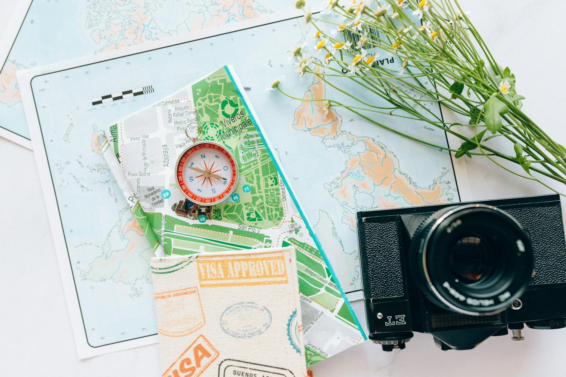 compass beside a map and camera